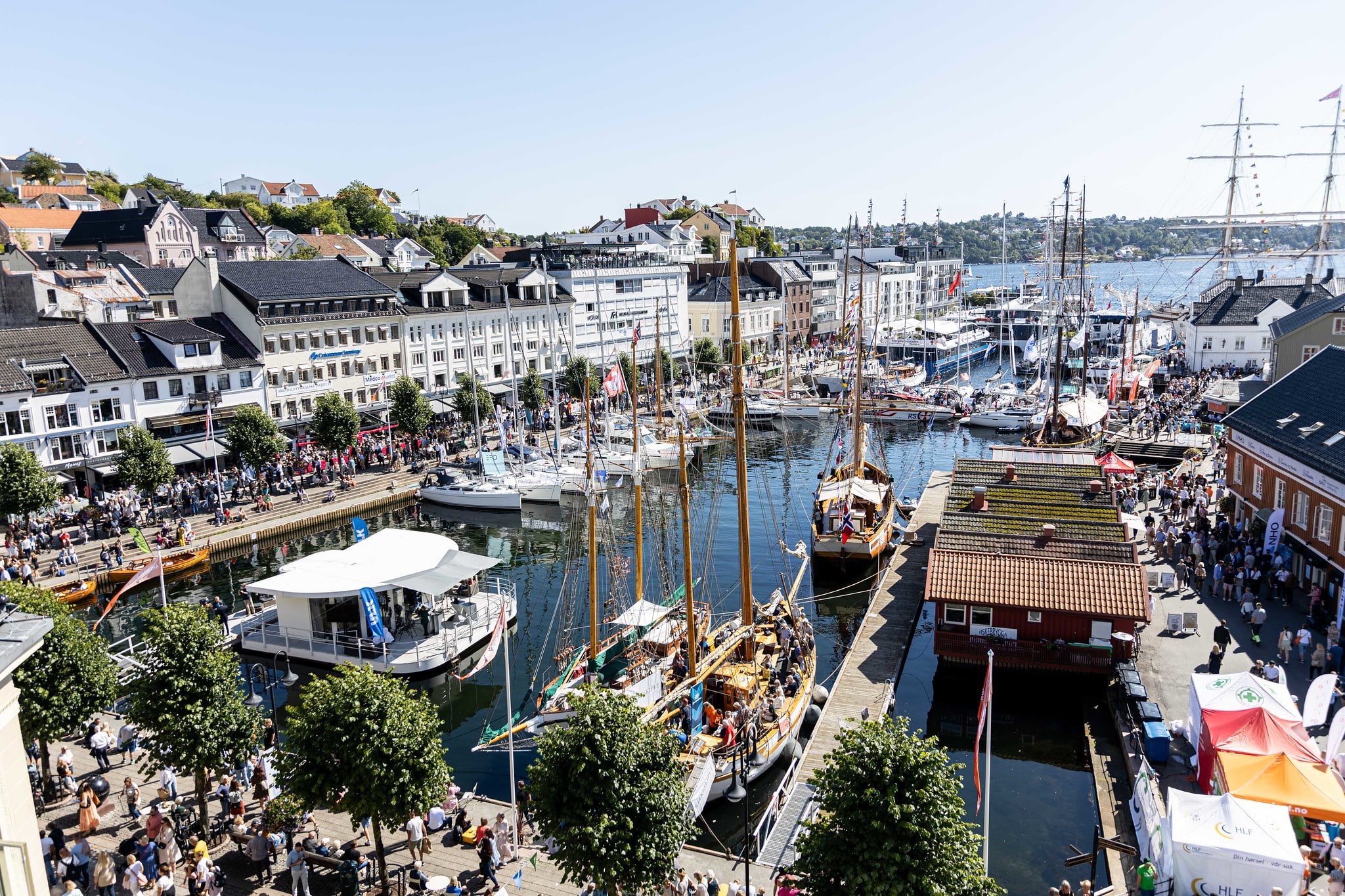 Bilde av havna i Arendal under Arendalsuka, med mange b&aring;ter og masse folk.